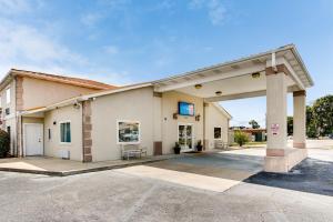 un gran edificio con un cartel en un estacionamiento en Motel 6-Hinesville, GA en Hinesville