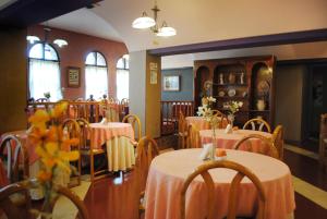 a restaurant with tables and chairs with pink table cloth at Hotel Gran International in Villa Gesell