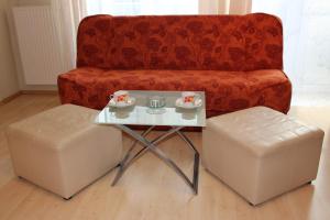 a coffee table and two stools in front of a couch at Riga Apartment Brivibas with Private Parking in Riga