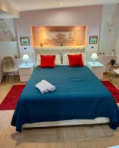 1 cama azul grande con 2 almohadas rojas. en Casa Etna Soul, en Paterno