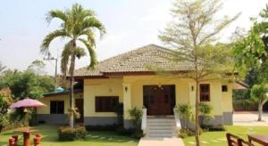 a small yellow house with a palm tree at OYO 769 Ban Thassanee in Chiang Mai