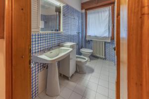 a blue tiled bathroom with a sink and a toilet at Casa Bigontina 19, in the center of Cortina in Cortina dʼAmpezzo +8 photos