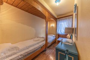 a small bedroom with two beds and a table at Casa Bigontina 19, in the center of Cortina in Cortina dʼAmpezzo