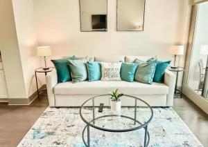 Una sala de estar con un sofá blanco con almohadas azules. en Serenity In The City, en Atlanta