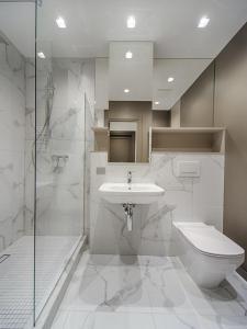 Un baño con lavabo, inodoro y ducha. en The Crown Guest House Karachi, en Karachi