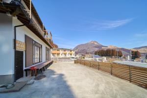a bench outside of a building with mountains in the background at OYADO YUKI ONSEN - Vacation STAY 87691 in Yufuin