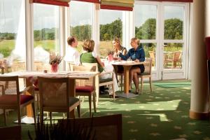 a group of people sitting at tables in a restaurant at Castello Apartments in Lüneburg