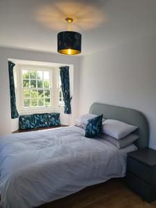 a bedroom with a large bed with a window at Number 10 - Stunning brand new house - sleeps 6 - free parking in Topsham
