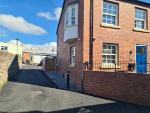 a brick building with a blue door and a driveway at Number 10 - Stunning brand new house - sleeps 6 - free parking in Topsham