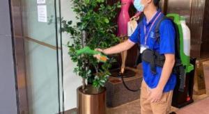 a man is standing next to a potted plant at Ehotel in Hong Kong