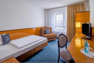 a hotel room with a bed and a table and a chair at Aspire Frankfurt Airport, Trademark Collection by Wyndham in Rüsselsheim +39 photos