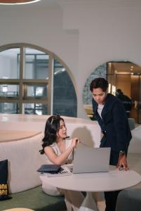 un homme et une femme assis à une table avec un ordinateur portable dans l'établissement 22 Macalisterz George Town By Mana-Mana, à George Town 91 autres photos