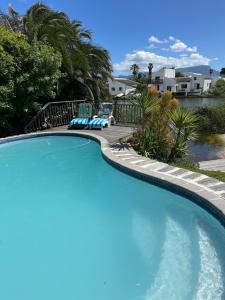 a large blue swimming pool with a patio and houses at Bella Vista Lago in Marina da Gama