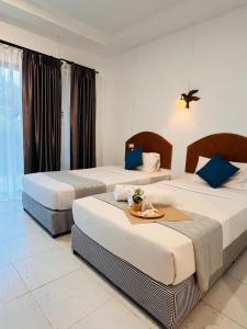 two beds in a hotel room with a table at Lanta Nesta Resort in Ko Lanta Yai +24 photos