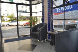 a waiting room with a chair and a bus at Hotel Aeroporto de Congonhas in Sao Paulo