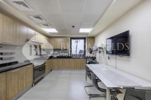 Una cocina con una mesa y sillas en una habitación. en Bloomfields Delux 2BR Miad Town House Mina, en Rūl Ḑadnā