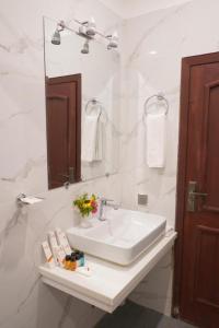 a white bathroom with a sink and a mirror at Envoy Express, Islamabad in Islamabad +32 photos