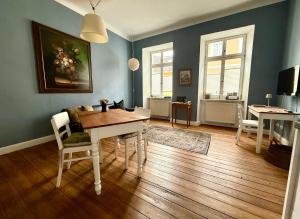 a dining room with blue walls and a table and chairs at Maison baroque in Blieskastel