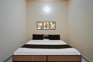 1 cama en una habitación con 3 cuadros en la pared en Hotel O Kukas Bus Terminal Formerly Stoneleaf Retreat, en Jaipur