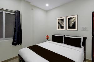a white bedroom with a black and white bed at Collection O Adibatla X Road, Near TCS, Wonderla Road in Ibrāhīmpatan