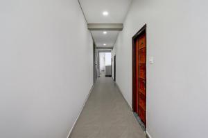 a corridor with a white wall and a door at Collection O Adibatla X Road, Near TCS, Wonderla Road in Ibrāhīmpatan