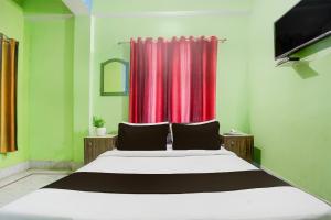 a bedroom with a large bed with a red curtain at Collection O Chhapra Railway Junction Formerly Hotel City Palace in Chupra