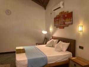 a bedroom with a bed and a clock on the wall at Margosa villa in Tangalle