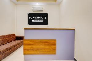 a room with a couch and a sign on the wall at Super Townhouse Guduvancheri Junction Formerly Zafe Commercial in Gūduvāncheri