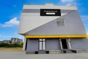 a building with a sign on the side of it at Townhouse Guduvancheri Junction Formerly Zafe Commercial in Madambakkam