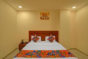 ein Schlafzimmer mit einem großen Bett mit bunten Kissen in der Unterkunft FabHotel Virat Elite in Hyderabad