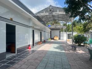 a large white building with a walkway in a courtyard at Nhà Nghỉ Phát Thành in Trà Vinh