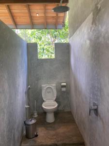 a bathroom with a toilet in a concrete wall at Margosa villa in Tangalle +57 photos