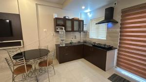 een keuken met een tafel en stoelen in een keuken bij Le divine in Guruvāyūr
