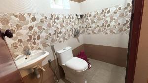 een badkamer met toilet en wastafel bij Le divine in Guruvāyūr