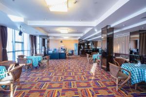 un restaurant avec des tables et des chaises sur un tapis dans l'établissement Datong Tiangui International Hotel, à Datong