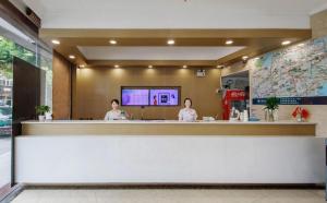 Due donne sedute al bancone in un ristorante di GreenTree Inn Jiaxing Tongxiang Tudian Express Hotel a Jiaxing