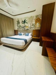 een slaapkamer met een groot bed met een schilderij aan de muur bij The White Castle Hotel in Mysore