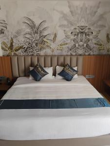 een slaapkamer met een wit bed met blauwe kussens bij The White Castle Hotel in Mysore