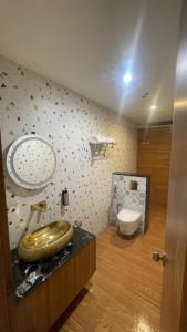 een badkamer met een gouden wastafel en een toilet bij The White Castle Hotel in Mysore