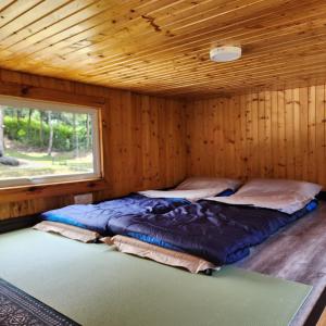 a bedroom with two beds in a wooden cabin at The Mountain Camp at Mesilau, Kundasang by PrimaStay in Ranau