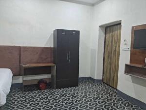 a room with a bed and a cabinet and a desk at Hotel O Smriti Villa in Ballygunge