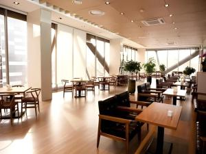 a restaurant with wooden tables and chairs and windows at Richell Hotel in Andong