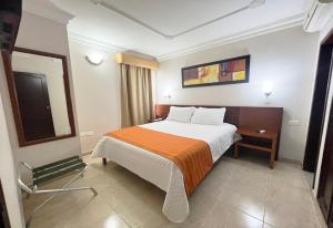 a hotel room with a bed and a mirror at Howard Johnson by Wyndham Barranquilla Versalles in Barranquilla +56 photos