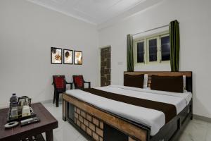 a bedroom with a bed with a table and chairs at Hotel O K K Guest House in Khagaul