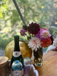 a table with two bottles and a vase of flowers at North Cascades Glamping with Hot-tub and Outdoor Kitchen in Rockport