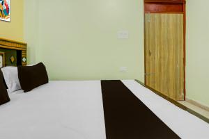 a bedroom with a bed with a black and white blanket at Hotel O Ansh Raj Hotel in Patna City