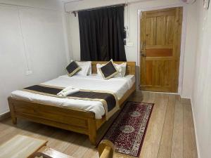 Un dormitorio con una cama y una puerta de madera. en Townhouse Howell Crossway Shillong (Formerly Laban Guest House, en Shillong