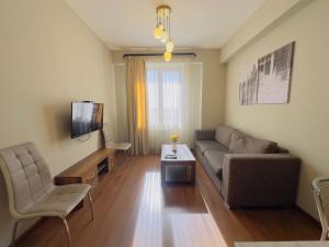 a living room with a couch and a tv at Orange apartments in Yerevan