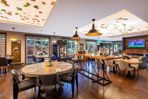 a restaurant with tables and chairs and a bar at Mercure Tbilisi Old Town in Tbilisi City
