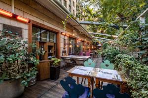 a patio with tables and chairs and plants at Mercure Tbilisi Old Town in Tbilisi City